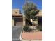 A close exterior view shows the brown garage doors and desert landscaping of the home at 8302 N 21St Dr # L204, Phoenix, AZ 85021
