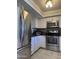 This bright kitchen is appointed with stainless steel appliances, white cabinets and granite countertops at 8302 N 21St Dr # L204, Phoenix, AZ 85021