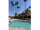 Stunning pool view, with community building, tall palms, and lounge seating at 8302 N 21St Dr # L204, Phoenix, AZ 85021