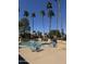 Community pool area with tables, chairs, and palm trees, ideal for relaxation and socializing at 8302 N 21St Dr # L204, Phoenix, AZ 85021