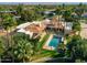 Aerial view of large home with swimming pool, tile roof, mature landscaping and palm trees at 8712 N 64Th Pl, Paradise Valley, AZ 85253