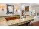Home bar with ornate wood trim, granite countertops, and mirrored wall decor at 8712 N 64Th Pl, Paradise Valley, AZ 85253