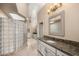 Elegant bathroom with granite countertops, glass block shower, and dual sinks at 8712 N 64Th Pl, Paradise Valley, AZ 85253