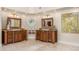 Spacious bathroom featuring dual wooden vanities with granite countertops, tile floors, and stained glass decor at 8712 N 64Th Pl, Paradise Valley, AZ 85253