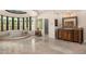 Bright bathroom featuring a tub with stained glass windows, marble floors, and vanity with custom mirror at 8712 N 64Th Pl, Paradise Valley, AZ 85253