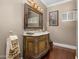 Bathroom displaying a detailed wood vanity with ornate mirror, elegant fixtures, and hardwood floors at 8712 N 64Th Pl, Paradise Valley, AZ 85253