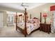 Floral themed bedroom featuring a four poster bed, ceiling fan, and carpet flooring at 8712 N 64Th Pl, Paradise Valley, AZ 85253