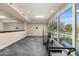 A spacious exercise room with mirrored wall, large windows, and access to the pool area at 8712 N 64Th Pl, Paradise Valley, AZ 85253