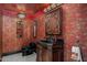 Unique powder room with ornate wallpaper, a black toilet and dark wood vanity at 8712 N 64Th Pl, Paradise Valley, AZ 85253