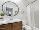 This bathroom features a vanity with a sink, a toilet, and a shower with a curtain, creating a functional space at 1051 W Inca St, Mesa, AZ 85201