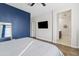 Stylish bedroom showcases a blue accent wall, wood-look floors, and a view of the bathroom at 1051 W Inca St, Mesa, AZ 85201