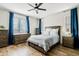 Bright bedroom featuring a ceiling fan, wood-look floors, and a coordinated furniture set with blue curtains at 1051 W Inca St, Mesa, AZ 85201