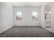Bright bedroom featuring neutral carpeting and two windows, conveniently located near the bathroom at 12029 W Marguerite Ave, Avondale, AZ 85323