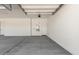 Clean, empty two car garage with concrete floor and white walls and doors at 12029 W Marguerite Ave, Avondale, AZ 85323