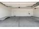 Clean, empty two car garage with concrete floor and white walls and doors at 12029 W Marguerite Ave, Avondale, AZ 85323