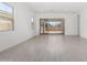 Sunlit living room with tile flooring and large windows offering views of the backyard at 12029 W Marguerite Ave, Avondale, AZ 85323
