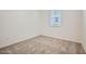 This bedroom has carpet flooring, neutral paint, and a window bringing in natural light at 15065 W Hackamore Dr, Surprise, AZ 85387