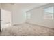 Bedroom with carpet, a small window and doorway to the en-suite bathroom at 15065 W Hackamore Dr, Surprise, AZ 85387