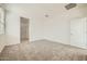 A bedroom with neutral carpet, a large window and entry to the bathroom at 15065 W Hackamore Dr, Surprise, AZ 85387