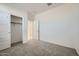 Well lit bedroom with plush carpeting, closet and doorway to the en-suite bathroom at 15065 W Hackamore Dr, Surprise, AZ 85387