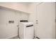 A clean laundry room with a modern white dryer and white cabinets at 15065 W Hackamore Dr, Surprise, AZ 85387