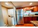 Galley kitchen featuring stainless steel refrigerator, stacked washer/dryer, and granite counters at 1645 W Baseline Rd # 2026, Mesa, AZ 85202