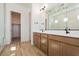 A spacious bathroom featuring a double vanity, a large mirror, and an adjacent closet for ample storage at 1892 E Empeltre Rd, San Tan Valley, AZ 85140