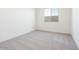 A sunlit bedroom showcasing neutral carpet and freshly painted white walls for a modern aesthetic at 1892 E Empeltre Rd, San Tan Valley, AZ 85140