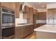 Modern kitchen with stainless steel appliances, quartz countertops, and wood cabinets at 1892 E Empeltre Rd, San Tan Valley, AZ 85140