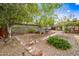 Inviting backyard with brick pathways, mature trees, and cozy seating arrangements at 1910 W Holly St, Phoenix, AZ 85009