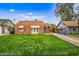 Charming brick home featuring a well-manicured lawn and classic striped awnings over the windows at 1910 W Holly St, Phoenix, AZ 85009