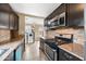 Well-equipped kitchen with sleek appliances, dark cabinets, and tile backsplash at 1910 W Holly St, Phoenix, AZ 85009