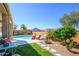 Beautiful backyard features a sparkling pool, inviting lounge chairs, and lush landscaping for outdoor enjoyment at 19672 N 260Th Ave, Buckeye, AZ 85396