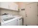 Functional laundry room features modern washer and dryer with ample storage space and a wash & dry sign at 19672 N 260Th Ave, Buckeye, AZ 85396