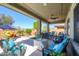 Covered patio features comfortable seating, ceiling fans, and stylish decor, creating an ideal outdoor living space at 19672 N 260Th Ave, Buckeye, AZ 85396