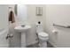 This powder room offers a pedestal sink, accessible toilet, and modern fixtures for a convenient and stylish space at 23800 N 169Th Ave, Surprise, AZ 85387
