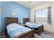 Cozy bedroom with two twin beds, a blue accent wall, and a window for natural light at 23800 N 169Th Ave, Surprise, AZ 85387
