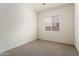 This bright and airy bedroom features a large window for natural light and neutral carpeting at 23800 N 169Th Ave, Surprise, AZ 85387