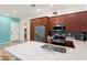 Kitchen showcasing white countertops, dark wood cabinets, stainless steel appliances, and a sink at 23800 N 169Th Ave, Surprise, AZ 85387