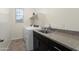 Functional laundry room featuring modern appliances, a sink with a countertop, storage cabinets, and a window at 23800 N 169Th Ave, Surprise, AZ 85387