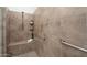 This walk-in shower features stylish tile work, a built-in bench, and grab bars for safety and accessibility at 23800 N 169Th Ave, Surprise, AZ 85387