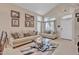 Bright living room with a vaulted ceiling, neutral-toned furniture, and decoratively framed Gathering portraits at 25038 W Rancho Vista Dr, Buckeye, AZ 85326