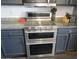 Close-up of a stainless steel double oven with granite countertops and custom cabinets at 3004 W Running Deer Trl, Phoenix, AZ 85083
