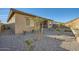 View of a landscaped backyard with drought-resistant gravel and young trees, showcasing a covered patio of the home at 3252 W Peak View Rd, Phoenix, AZ 85083
