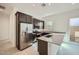 Modern kitchen with stainless steel appliances, stone countertops, and eat-in island at 3252 W Peak View Rd, Phoenix, AZ 85083