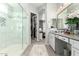 This stylish bathroom has a double vanity and a glass shower next to a walk-in closet and bedroom at 3527 E Arabian Dr, Gilbert, AZ 85296