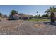 Backyard showcasing desert landscaping, lush lawn, covered patio, and private pool at 3620 N Aspen Dr, Avondale, AZ 85392