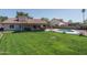 Private backyard oasis featuring a pool, lush green lawn, and a covered patio for outdoor enjoyment at 3620 N Aspen Dr, Avondale, AZ 85392