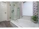 Bright bathroom with a soaking tub, a subway tiled shower, and neutral flooring at 3620 N Aspen Dr, Avondale, AZ 85392