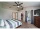 Bedroom showing walk-in closet and access to a bathroom with a ceiling fan at 3620 N Aspen Dr, Avondale, AZ 85392